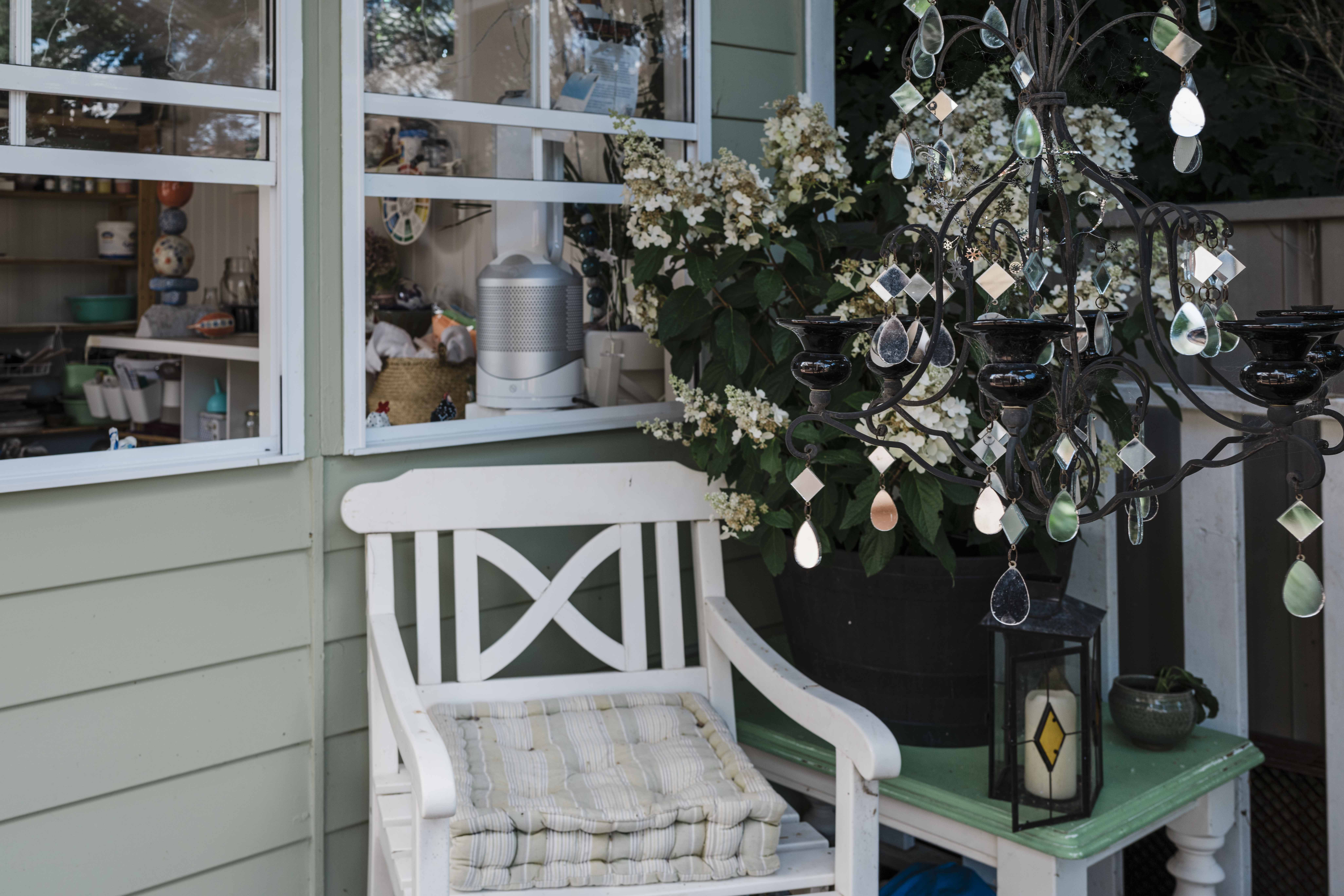 chair and table on porch in front of open windows