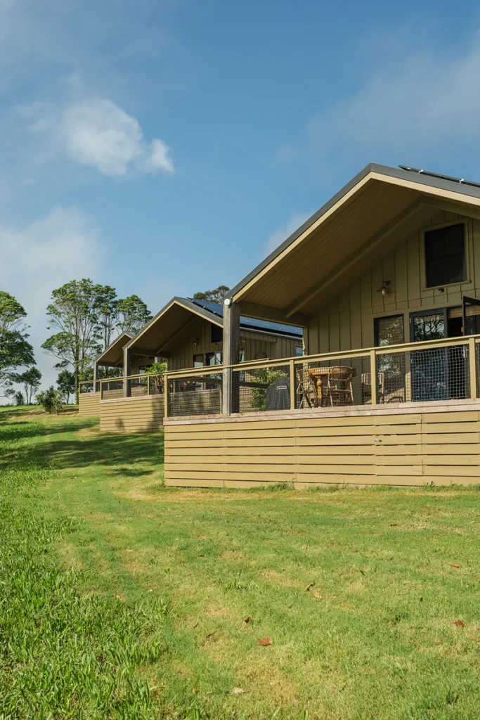 Row of barns with wrap-around decks on open grassy ridge